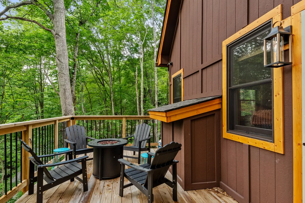 An inviting fire pit area with Adirondack chairs encircled by lush greenery. The warm glow of the fire suggests post-adventure gatherings under the stars, perfect for sharing stories after a day outdoors.