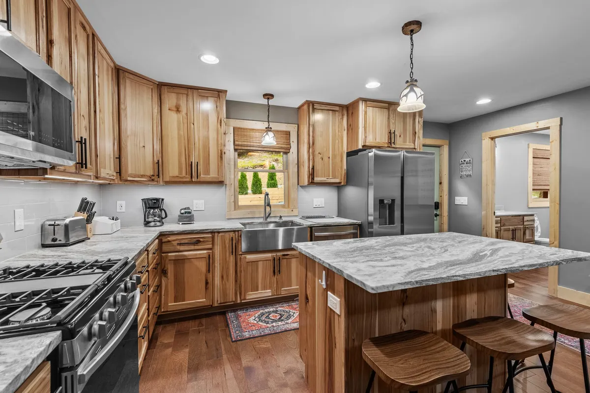 Another perspective on the kitchen, showcasing the kitchen island, ample counter space, stainless steel appliances, and lots of natural light. The cozy, welcoming atmosphere makes it easy to imagine preparing and sharing memorable meals together.